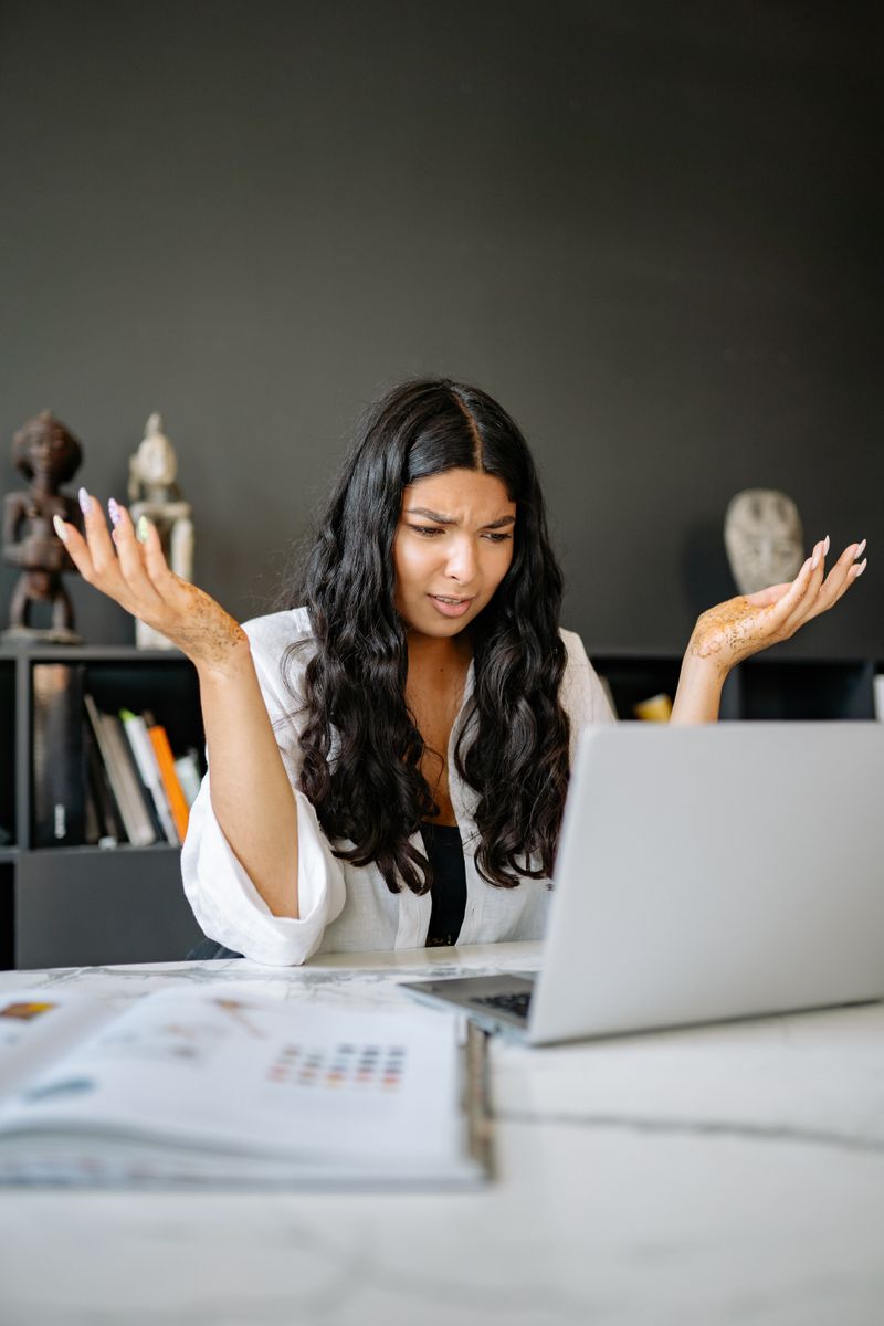 Femme perplexe devant son ordinateur, doutant du resultat d’un quiz de grossesse en ligne