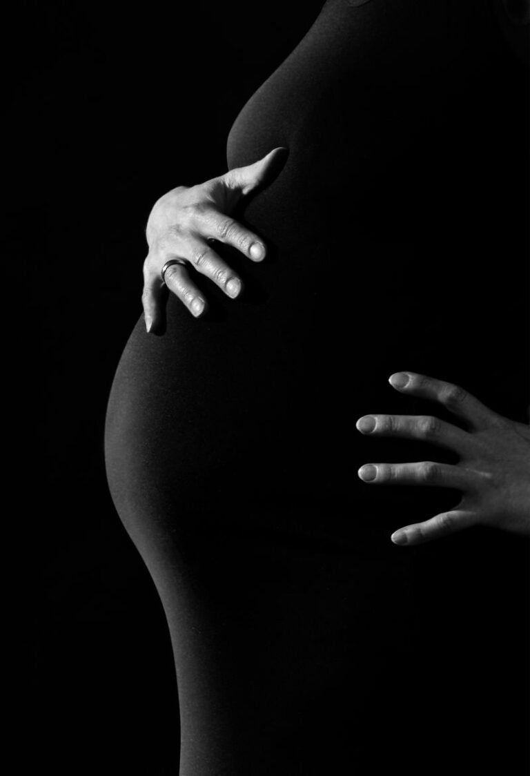 Femme enceinte tenant doucement son ventre, illustration des pertes blanches pendant la grossesse