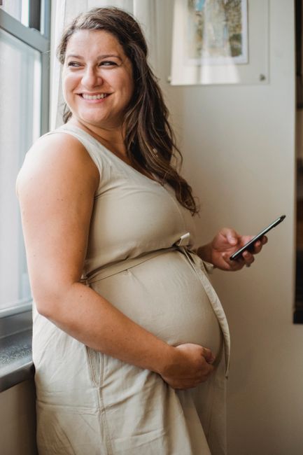 Femme enceinte de 4 mois souriante tenant son ventre