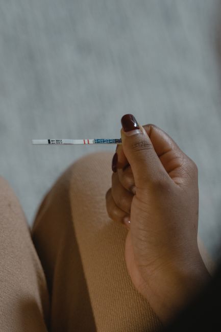 Test de grossesse tenu en main, pour confirmer une grossesse apres un changement de glaire cervicale