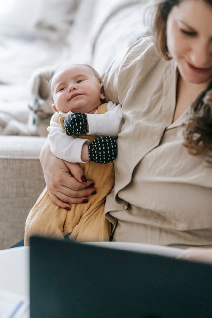 Maman effectuant une démarche CAF en ligne avec son bébé
