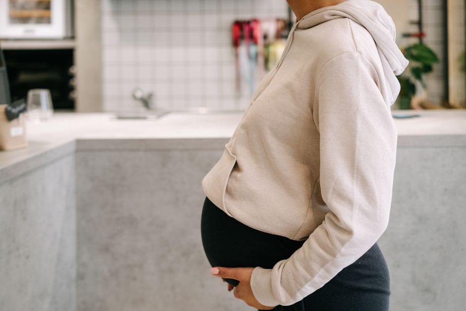 Femme enceinte en tenue confortable tenant son ventre