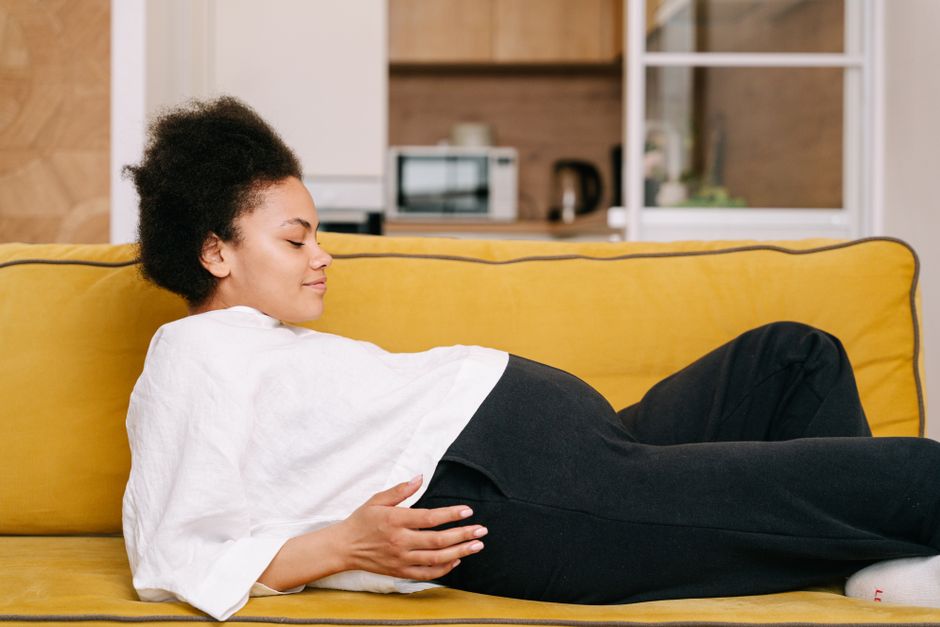 Femme enceinte au troisième trimestre se reposant confortablement à la maison