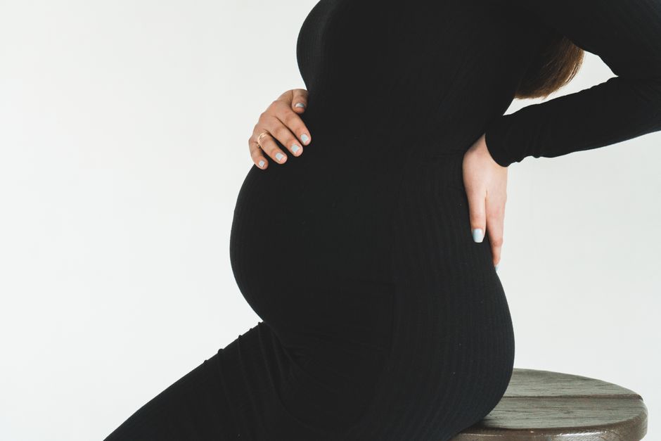 Femme enceinte tenant son dos et son ventre
