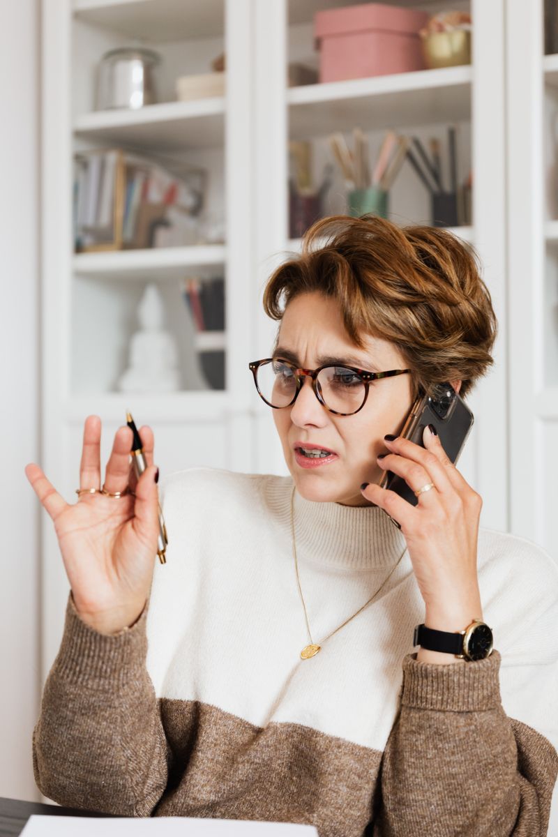 Femme au telephone avec une expression interrogative, remplissant un quiz de symptomes de grossesse