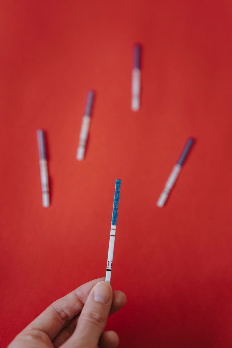 Main tenant une bandelette de test de grossesse urinaire, seul moyen fiable de confirmer une grossesse