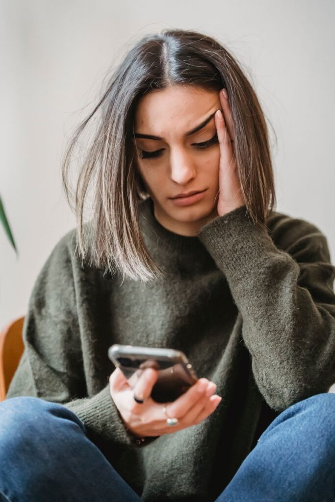 Femme allongee consultant son smartphone, cherchant des informations sur un test en ligne de grossesse