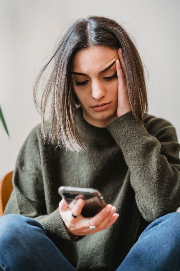 Femme allongee consultant son smartphone, cherchant des informations sur un test en ligne de grossesse