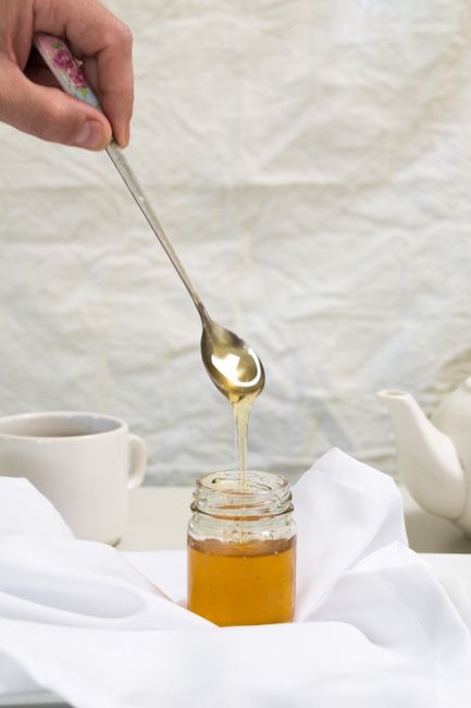 Cuillere de miel au dessus d un pot de miel