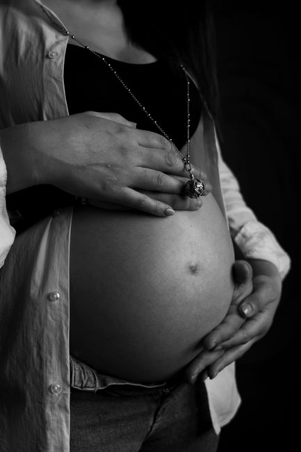 Femme enceinte tenant son ventre avec un collier bola