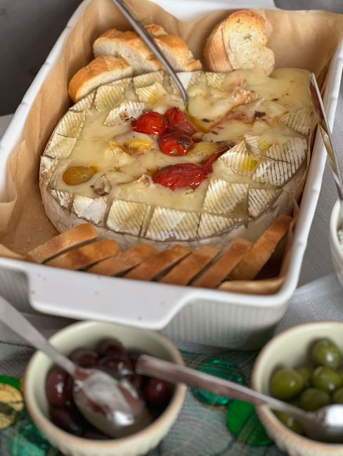 Camembert cuit au four servi avec olives et tomates