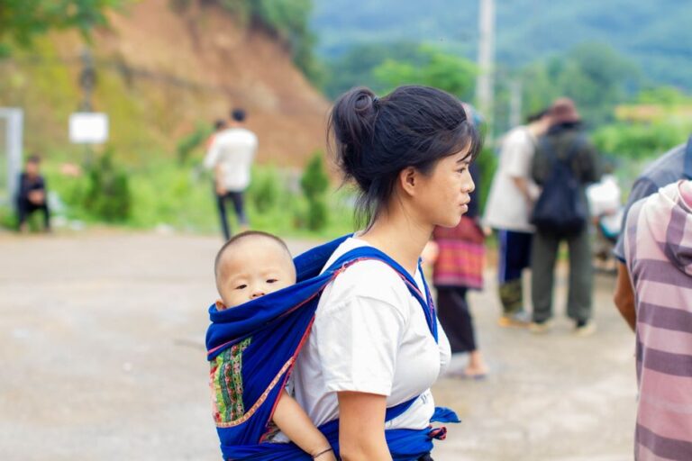 Femme portant son bebe dans une echarpe de portage
