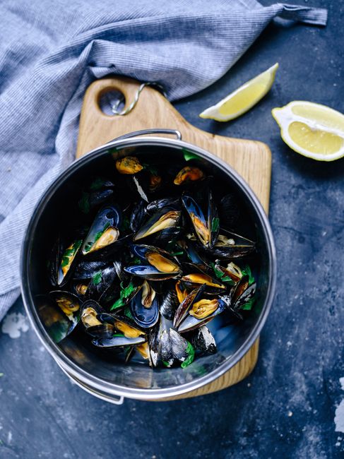 Pot de moules cuites servies avec herbes et citron