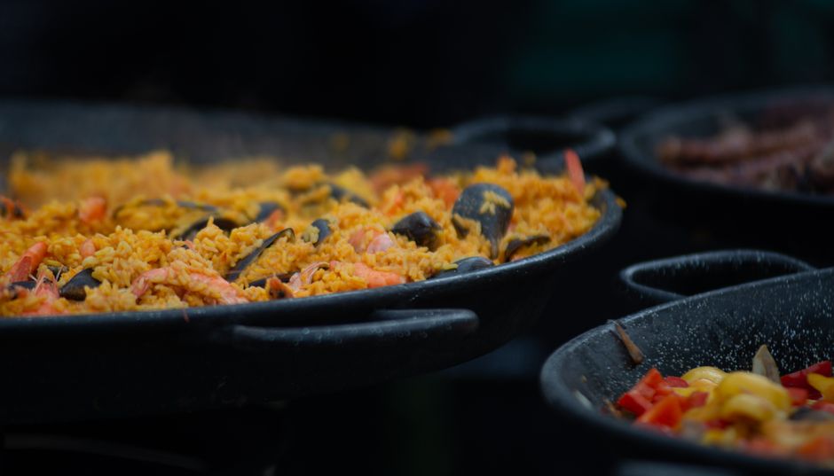 Paella en cours de cuisson dans un grand plat