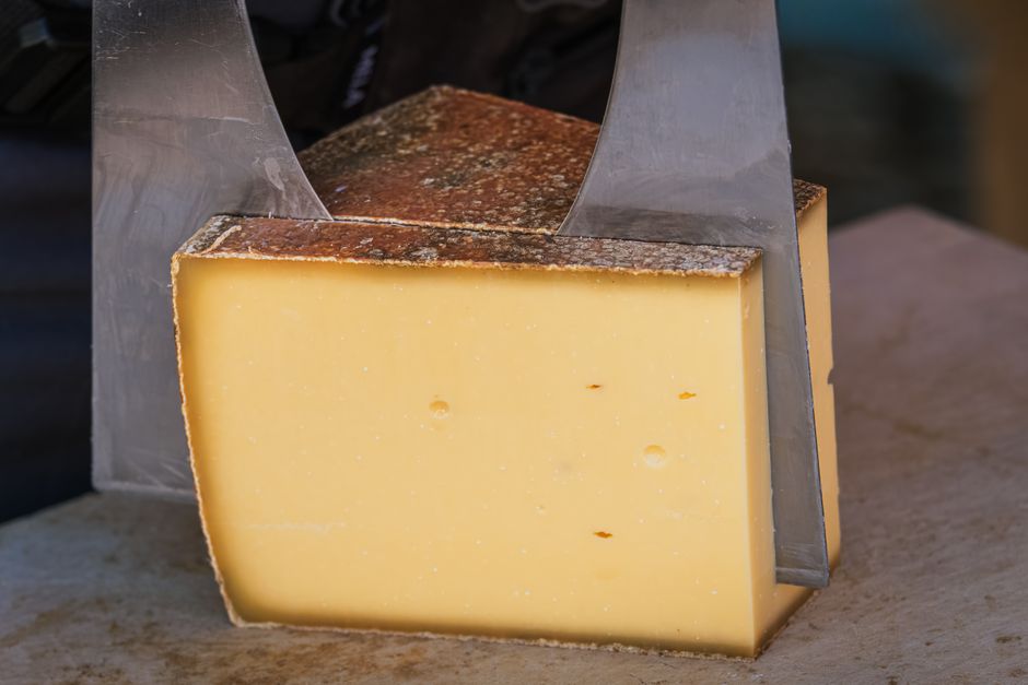Meule de fromage à pâte pressée tranchée pour une raclette