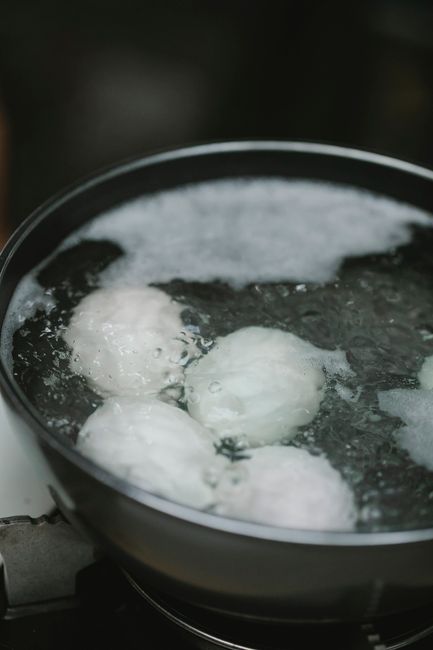 Œufs en train de cuire dans une casserole d'eau bouillante